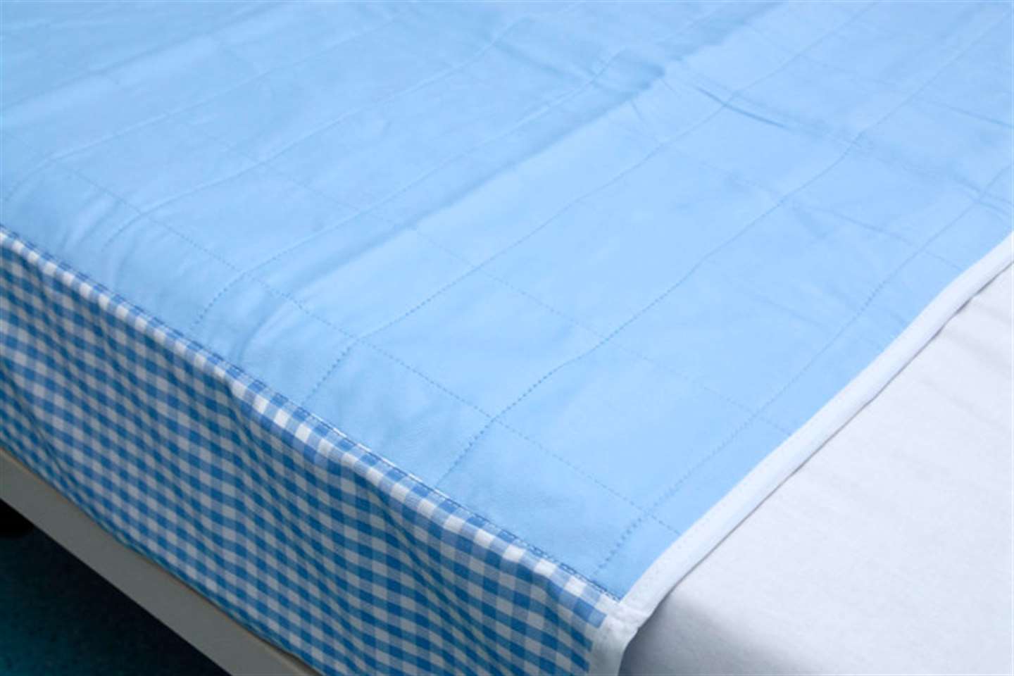 Washable bed pad with integral waterproof backing and tuck in flaps